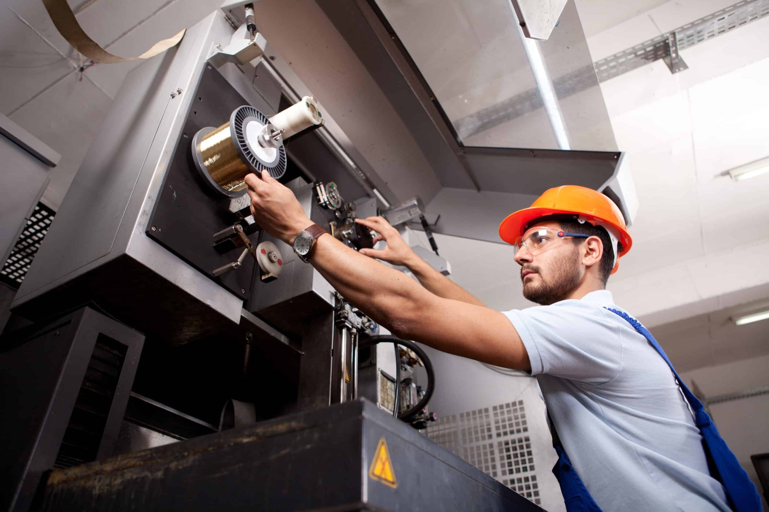 Young manual worker working in factory.